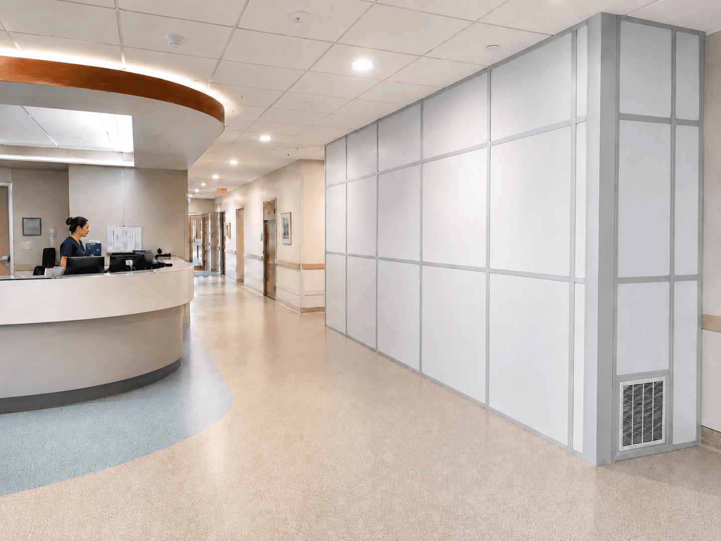 Healthcare ICRA containment — nurse at a hospital nursing station beside a sealed corridor with TWS modular wall panels