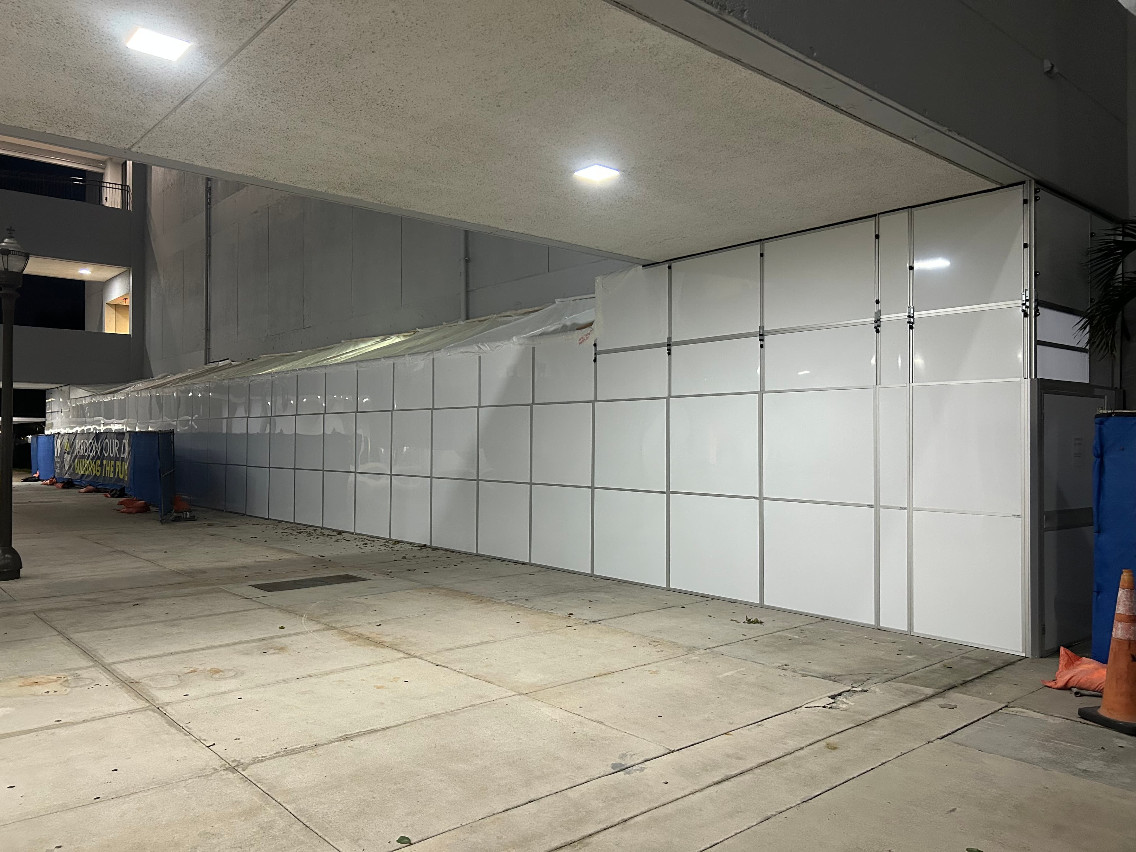 Modular temporary containment wall installed along a covered walkway at a Southeast Florida facility